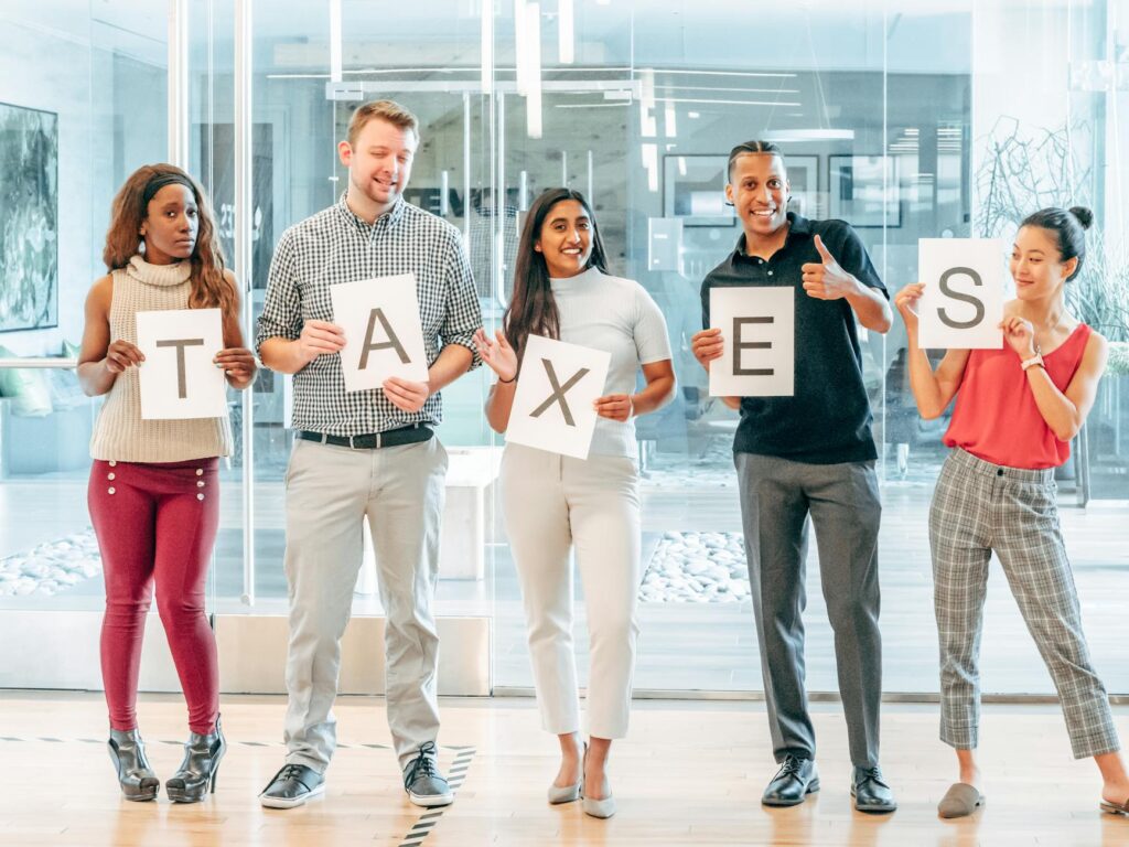 A diverse group of salaried employees from different countries reviewing documents, symbolizing global tax saving tips and employee tax planning strategies.