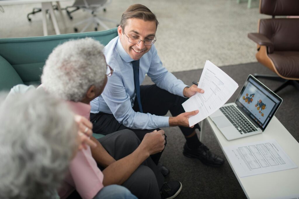 Millennials from diverse backgrounds using a retirement calculator on a laptop, discussing retirement savings tips and financial future