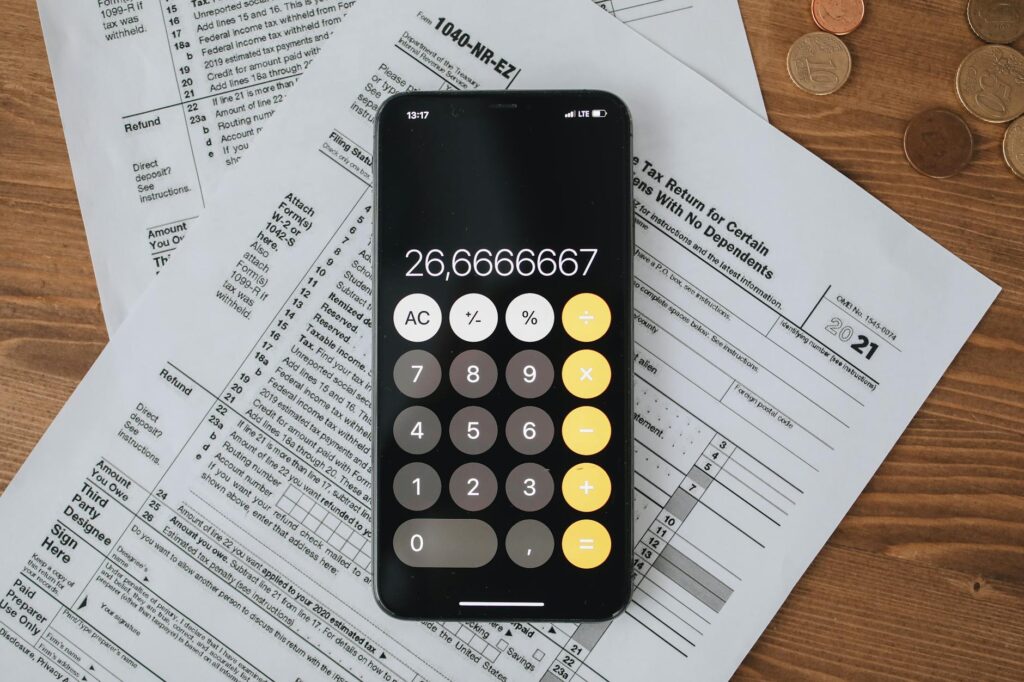 Freelancer calculating UAE income tax with documents, laptop, and calculator on a desk