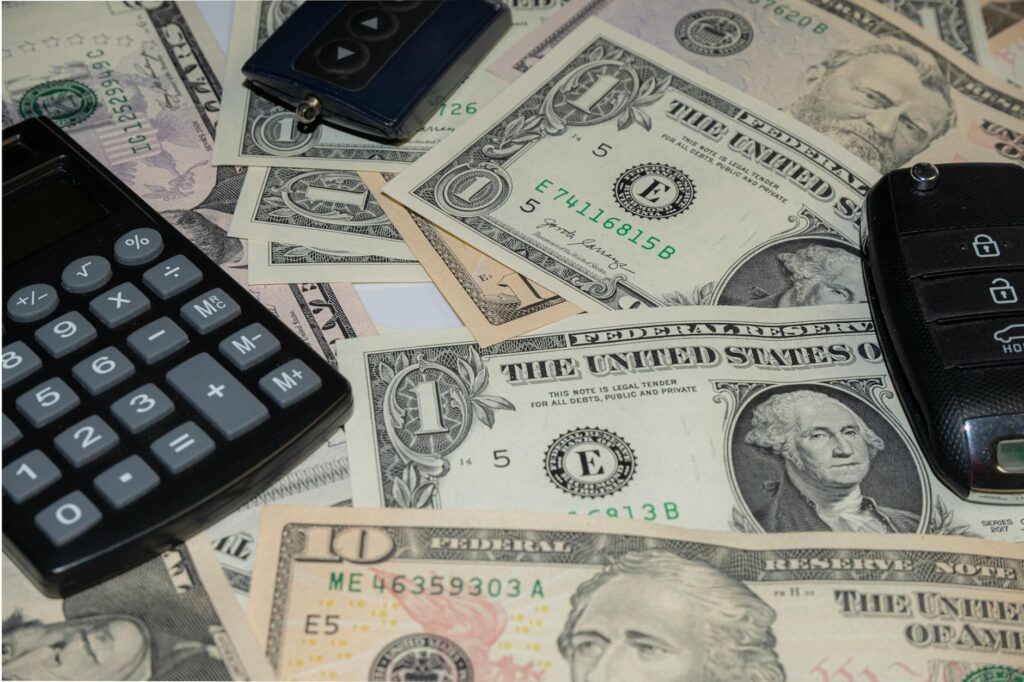 Person calculating fuel costs for daily commute on a table with a car dashboard showing a fuel gauge and coins, symbolizing money savings and budgeting.