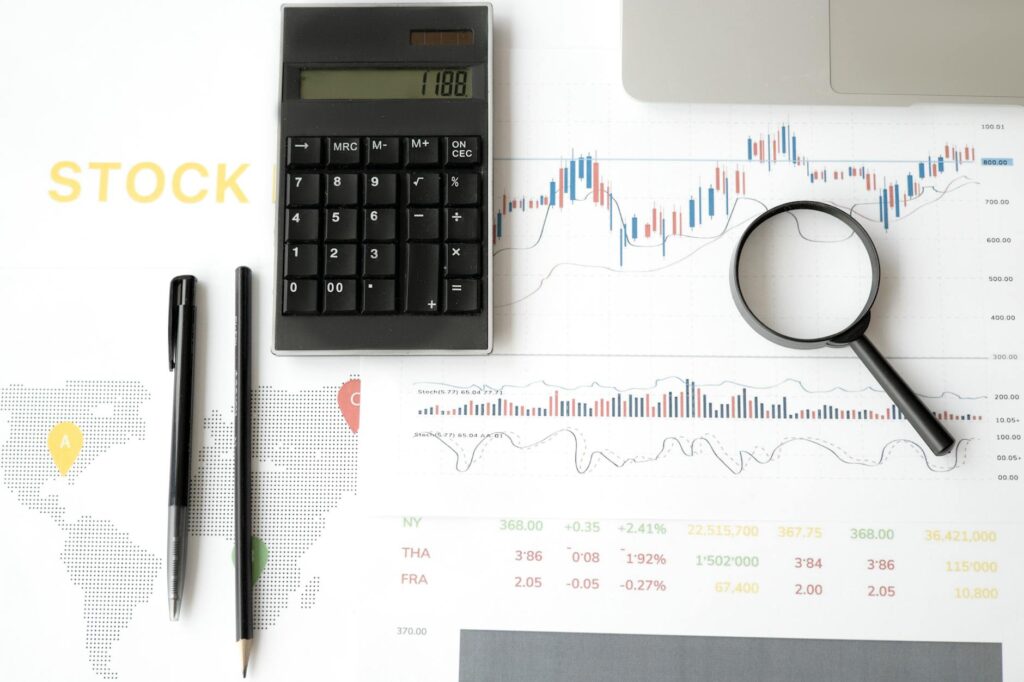 A person using an investment planning calculator on a tablet, surrounded by financial charts and graphs, symbolizing future wealth planning in 2026.