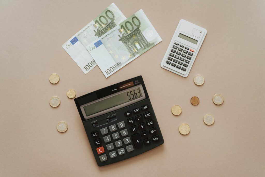 An online seller using a VAT calculator online on a laptop, surrounded by e-commerce packaging and tax documents, illustrating VAT for ecommerce compliance.