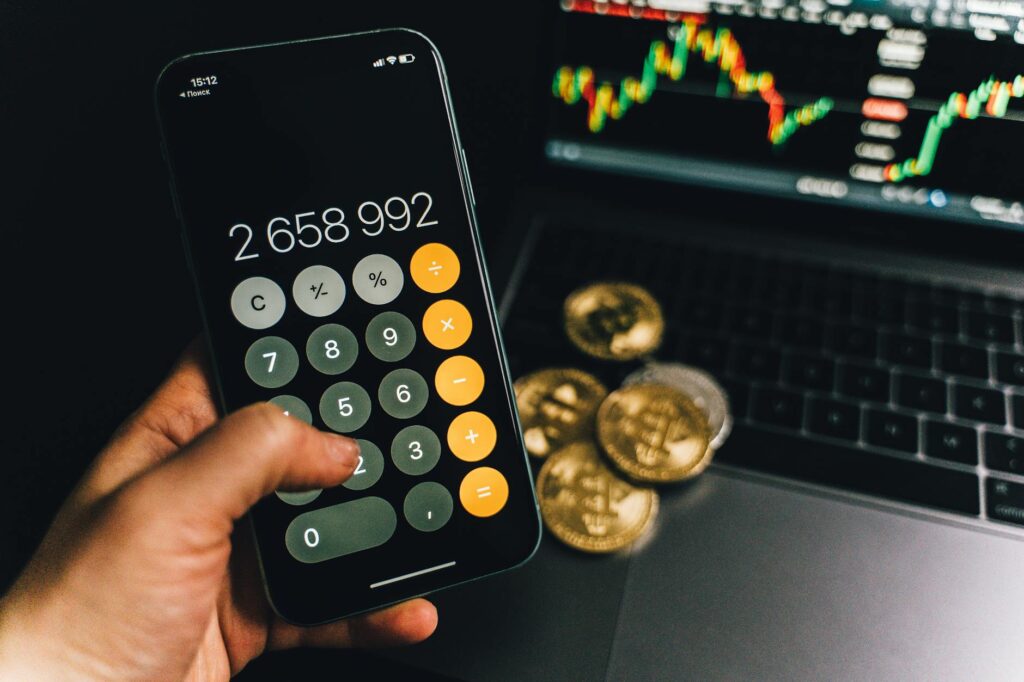 A person using a crypto tax calculator on a laptop, surrounded by cryptocurrency symbols and charts, illustrating the process of managing crypto profits.